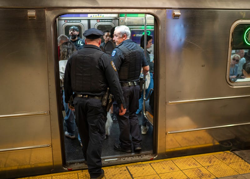 Two NYPD officers board a subway car in October
