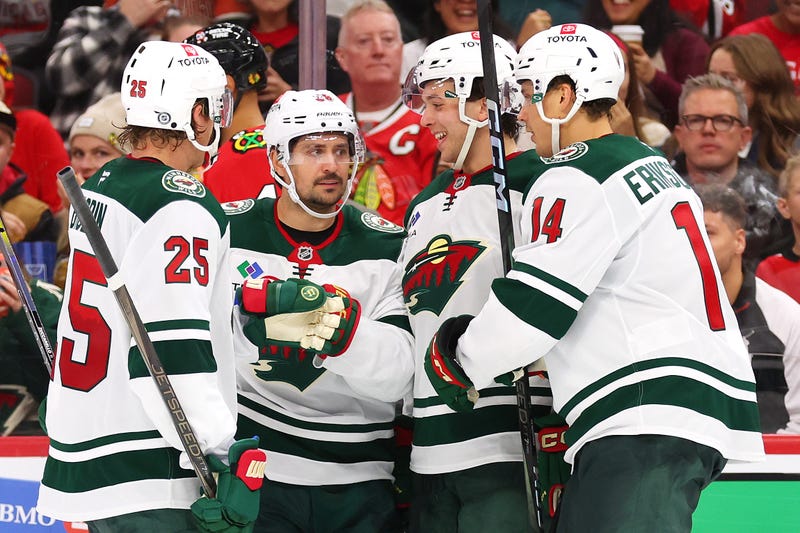 Brock Faber #7 of the Minnesota Wild celebrates with teammates after scoring a goal against the Chicago Blackhawks during the third period of a preseason game at the United Center on October 04, 2024 in Chicago, Illinois. 