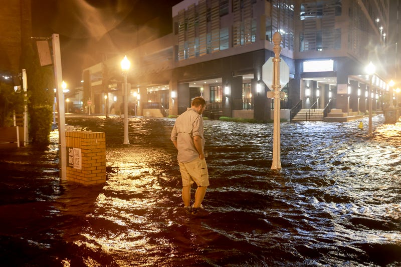 Brandon Marlow walks through surge waters flooding the street after Hurricane Milton came ashore in Fort Myers, Florida.