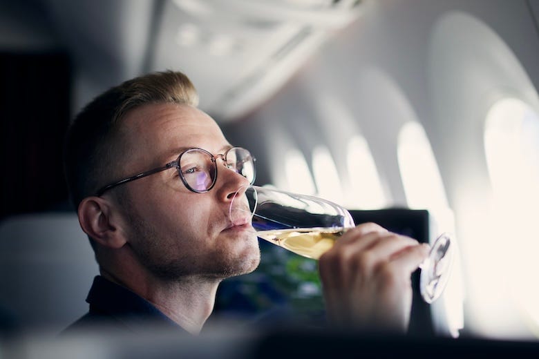 Man sipping champagne on an airplane