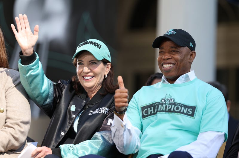 Governor of New York Kathy Hochul (L) and New York City Mayor Eric Adams react on stage during the New York Liberty Championship ticker tape parade celebrating winning the 2024 WNBA Finals on October 24, 2024