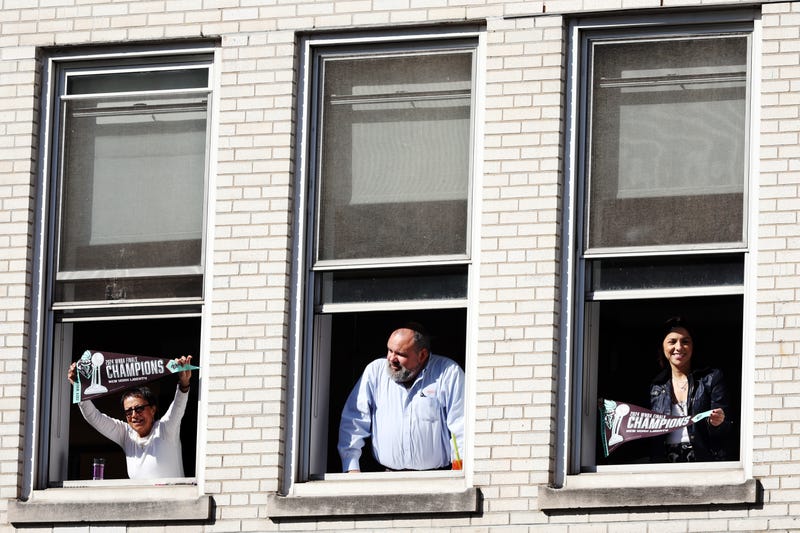 Fans cheer from windows during the New York Liberty Ticker Tape Victory Parade & Rally on October 24, 2024