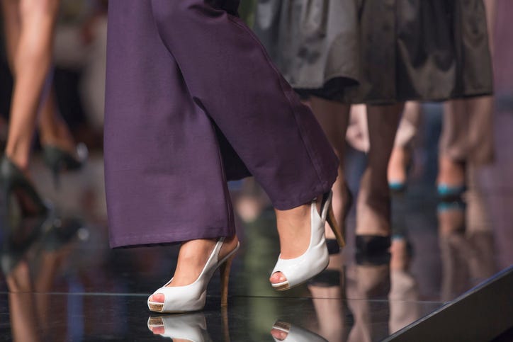Women wearing high heels walking on catwalk runway
