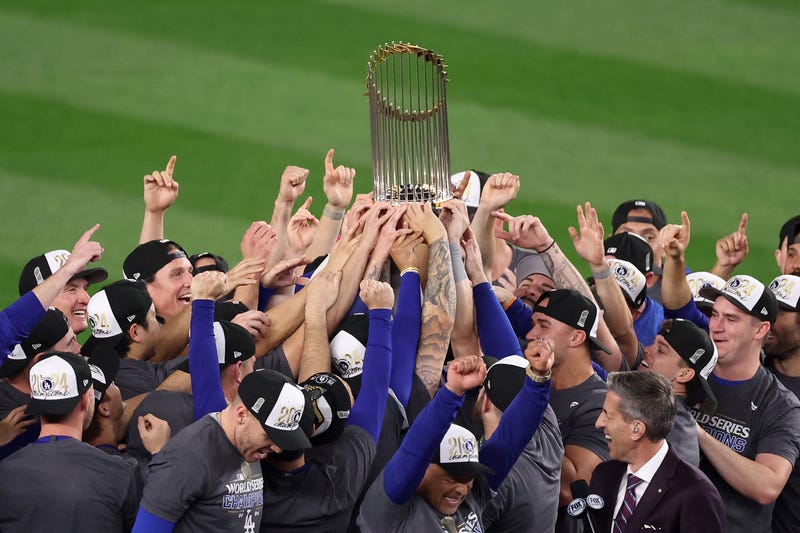  The Los Angeles Dodgers celebrate with the trophy after defeating the New York Yankees 7-6 in game 5 to win the 2024 World Series at Yankee Stadium on October 30, 2024 in the Bronx borough of New York City. 