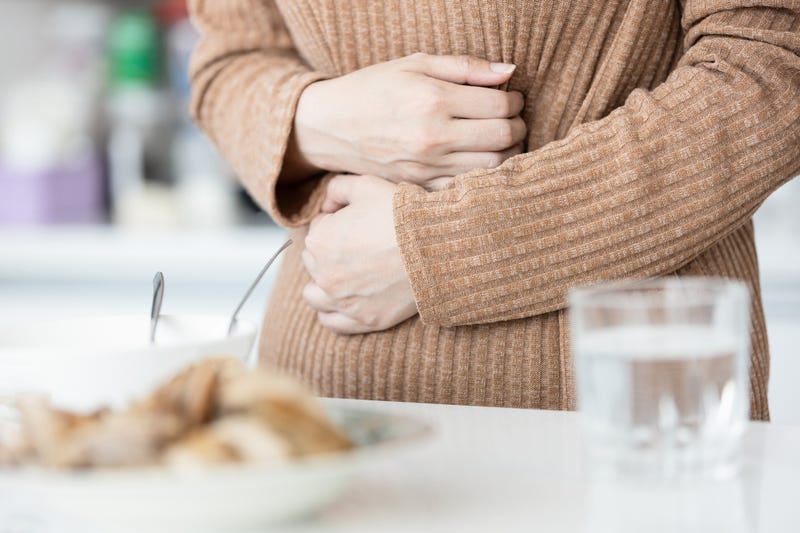 Sick woman has pain in abdomen while eating.