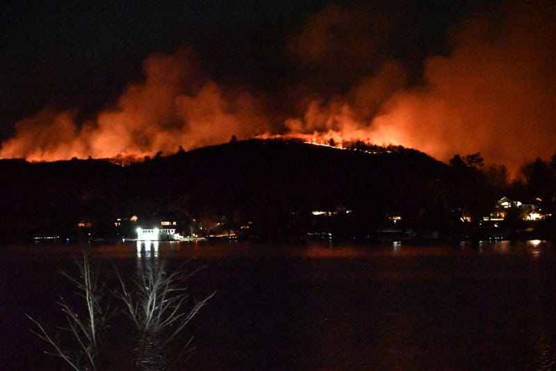 Smoke and flames rise as wildfire burns and spreads on a mountain in West Milford, New Jersey on Nov. 9, 2024. Large flames have overtaken the mountain and more than 2000 acres have burned.