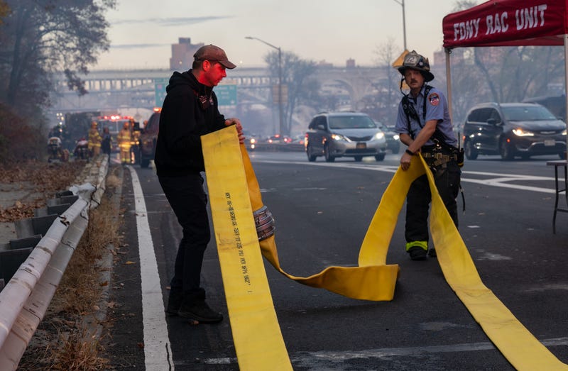 Firefighters try to extinguish a fast-moving brush fire along Harlem River Drive in Manhattan on November 19, 2024