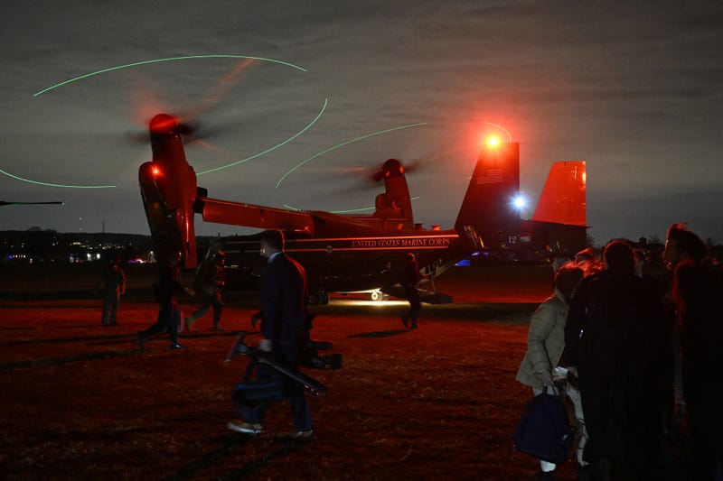 Members of the White House Press pool (R) stand by an Osprey after US President Joe Biden and First Lady Jill Biden departed from Miller Field in Staten Island, New York, November 25, 2024, en route to John F. Kennedy International Airport