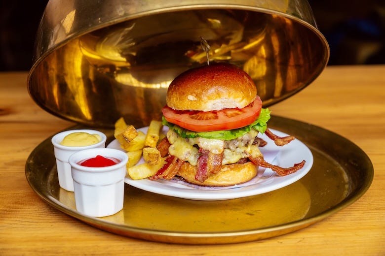 Gourmet cheeseburger sold on a golden tray