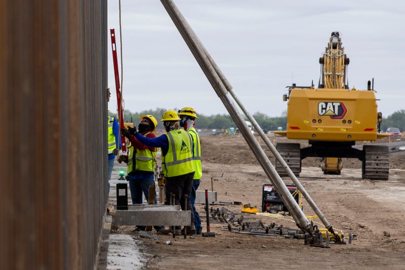 Construction crews install panels of the border wall where Texas Land Commissioner Dawn Buckingham is to hold a news conference to commemorate the state-sponsored construction on November 26, 2024 in La Casita-Garciasville, Texas.