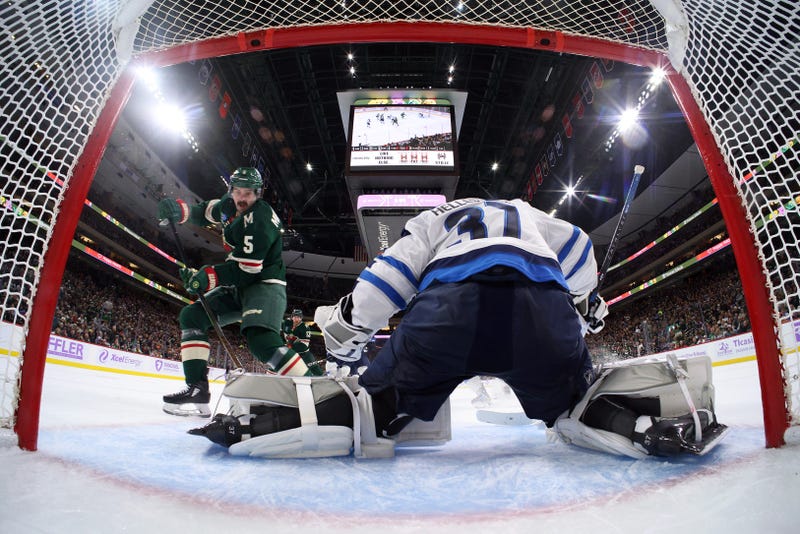 Connor Hellebuyck #37 of the Winnipeg Jets makes a save against Jake Middleton #5 of the Minnesota Wild in the second period at Xcel Energy Center on November 25, 2024 in St Paul, Minnesota. The Jets defeated the Wild 4-1.