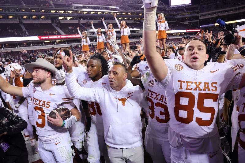 Quinn Ewers #3 and Head Coach Steve Sarkisian of the Texas Longhorns celebrate with teammates and the fans after defeating the Texas A&M Aggies 17-7 at Kyle Field on Nov. 30, 2024, in College Station, Texas.