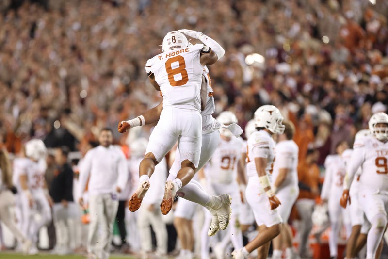 Trey Moore #8 of the Texas Longhorns celebrates his strip sack with Alfred Collins #95 during the fourth quarter against the Texas A&M Aggies at Kyle Field on Nov. 30, 2024, in College Station, Texas.