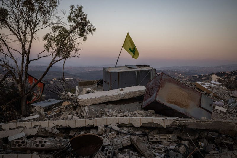 A Hezbollah flag stands on rubble left by an Israeli airstrike on December 3, 2024 near Kherbet Selem, Lebanon.
