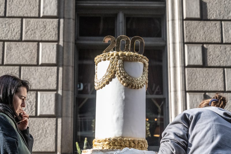 A cake with a 200 on top sits on a car-free pedestrian walkway along Fifth Ave for its anniversary on Dec. 8, 2024