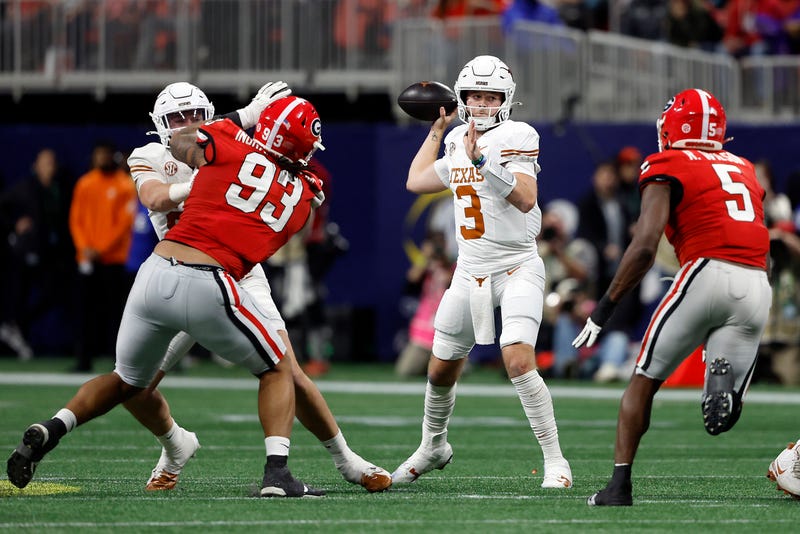 Quinn Ewers #3 of the Texas Longhorns looks to pass the ball under pressure against Tyrion Ingram-Dawkins #93 and Raylen Wilson #5 of the Georgia Bulldogs during the second quarter of the 2024 SEC Championship at Mercedes-Benz Stadium on Dec. 7, 2024, in Atlanta, Georgia.