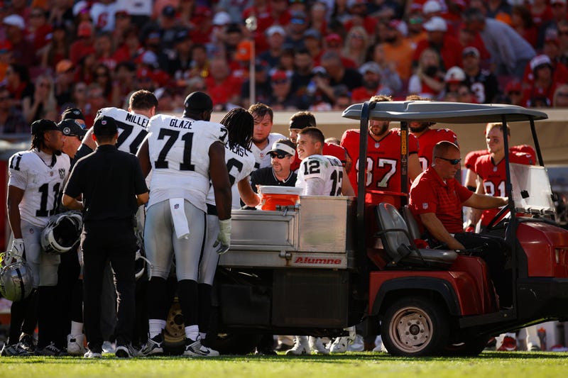 Aidan O'Connell #12 of the Las Vegas Raiders is assisted off the field by medical staff after an apparent injury during the third quarter against the Tampa Bay Buccaneers at Raymond James Stadium on December 08, 2024 in Tampa, Florida.