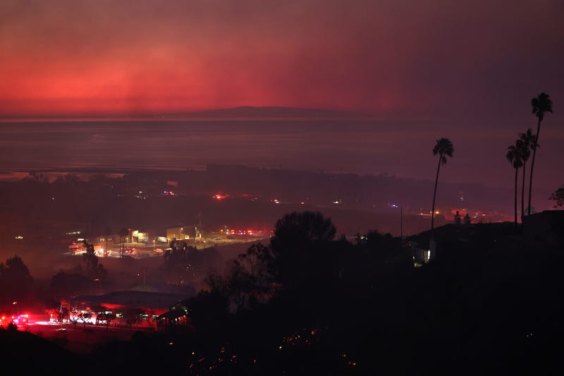 MALIBU, CALIFORNIA - DECEMBER 10: The Franklin Fire burns at dawn with the Pacific Ocean visible in the distance on December 10, 2024 in Malibu, California. The wildfire has scorched 1,800 acres near Pepperdine University prompting evacuations along the coast amid high winds with some structures destroyed.