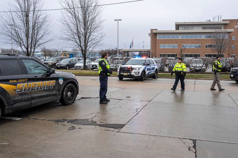 Law enforcement stand near a health care clinic where students from Abundant Life Christian School will be reunited with their parents after a school shooting on December 16, 2024 in Madison, Wisconsin.