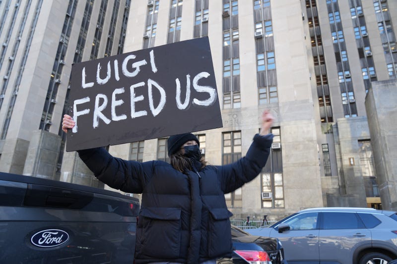 A woman named Mary holds a sign in support of Luigi Mangione outside the Criminal Court building in lower Manhattan on December 19, 2024