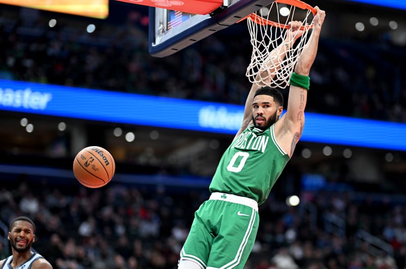 Jayson Tatum #0 of the Boston Celtics hangs on the rim after dunking in the fourth quarter against the Washington Wizards at Capital One Arena on December 15, 2024 in Washington, DC.