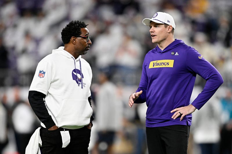Former Minnesota Vikings player Cris Carter speaks with ead coach Kevin O'Connell of the Minnesota Vikings prior to a game against the Chicago Bears at U.S. Bank Stadium on December 16, 2024 in Minneapolis, Minnesota.