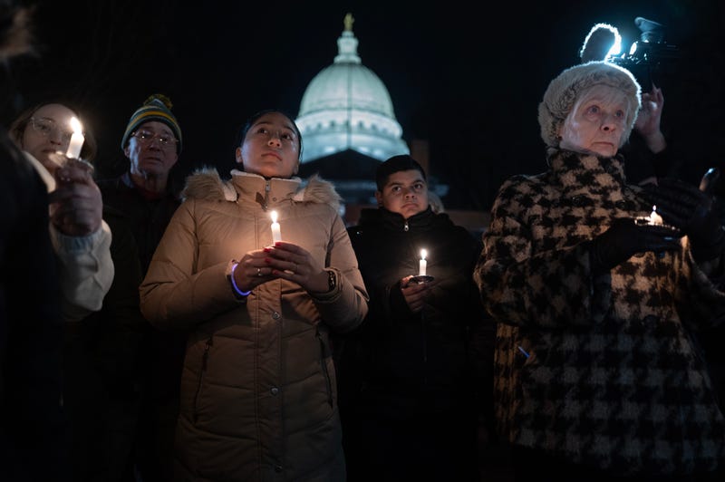 People attend a vigil on the grounds of the state Capital building