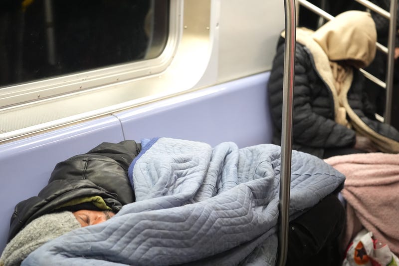 Homeless people take shelter in a subway car on December 22, 2024