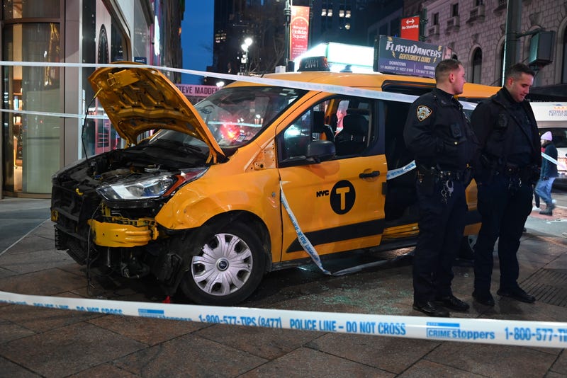 NYPD officers stand near the smashed taxi at Herald Square on Dec. 25, 2024