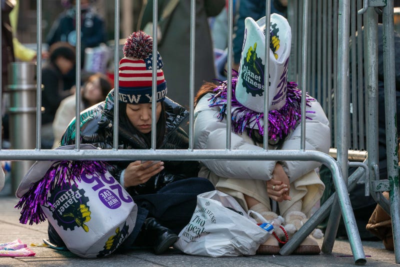 Revelers sit in Times Square prior to the New Year's Eve celebrations on December 31, 2024 .