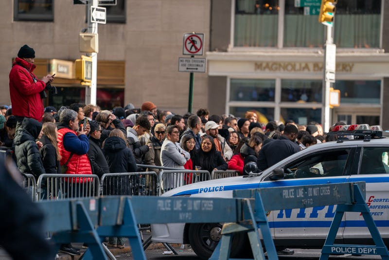Revelers wait in line on Sixth Avenue to clear security prior to entering Times Square on December 31, 2024.