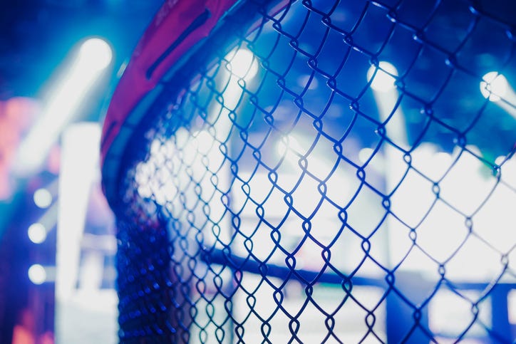 MMA cage arena lit by spotlights, Mixed martial arts fight night event