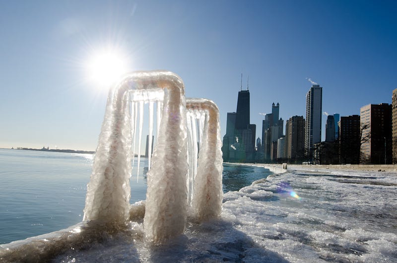 The Chicago skyline is reflected in a frozen lake