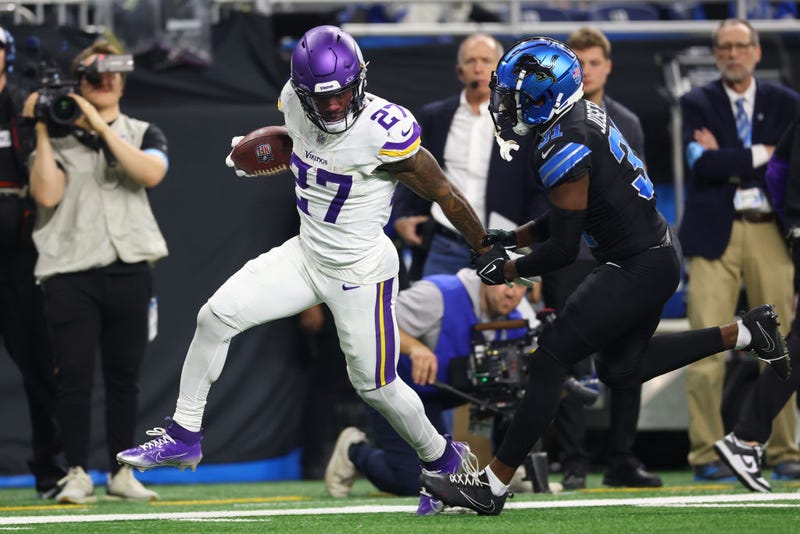 Cam Akers #27 of the Minnesota Vikings is tackled by Kerby Joseph #31 of the Detroit Lions during the third quarter at Ford Field on January 05, 2025 in Detroit, Michigan. 
