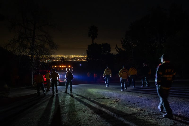 Firefighters from Seattle, WA walk to their fire trucks after a briefing meeting outside Sullivan Canyon Park right before midnight to start fighting the Palisades Fire on Jan. 10, 2025, in Los Angeles, California.