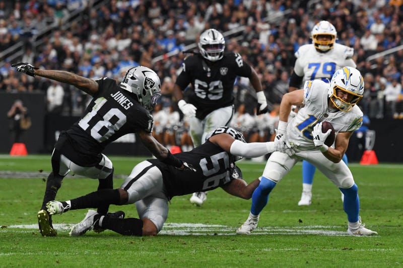 Ladd McConkey #15 of the Los Angeles Chargers breaks a tackle from Jack Jones #18 and Amari Burney #56 of the Las Vegas Raiders in the first quarter of their game at Allegiant Stadium on January 05, 2025 in Las Vegas, Nevada.