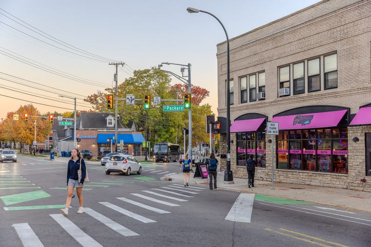 People walking across a crosswalk on Packard Street in Ann Arbor