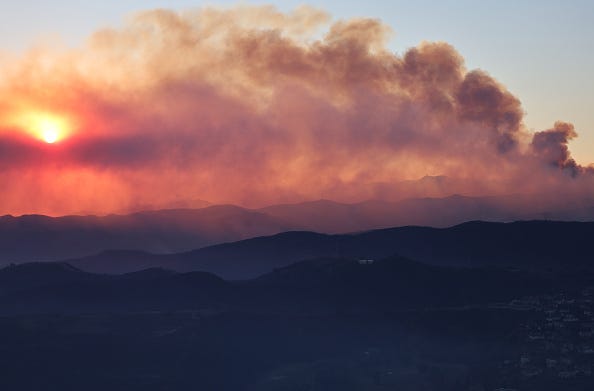 An aerial view shows the Palisades Fire continuing to burn as the sun sets on January 09, 2025 near Pacific Palisades, California.