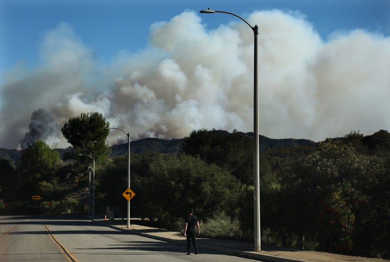 A person walks as the Palisades Fire continues to burn as wildfires cause damage and loss through Los Angeles County on Jan. 10, 2025, in Topanga, California.