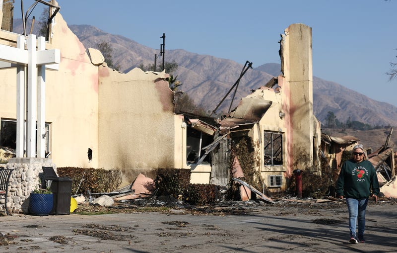 A person walks past the remains of senior living facility which was destroyed in the Eaton Fire, as wildfires cause damage and loss through the LA region on January 11, 2025 in Pasadena, California. 