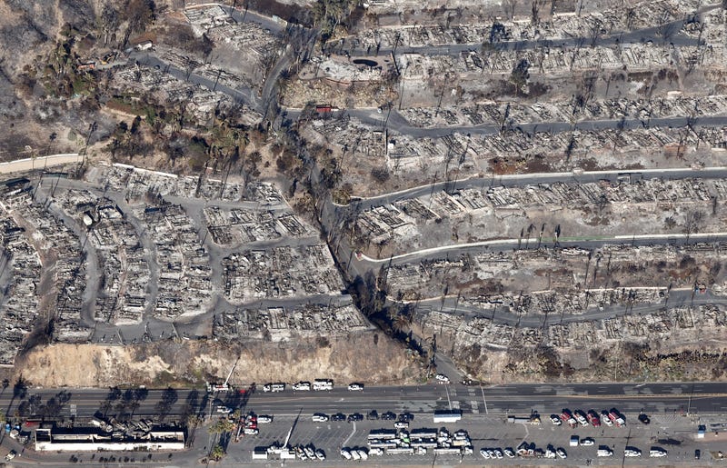 An aerial view of fire trucks, utility, and other vehicles parked near homes destroyed in the Palisades Fire as wildfires cause damage and loss through the LA region on January 13, 2025 in Pacific Palisades, California.