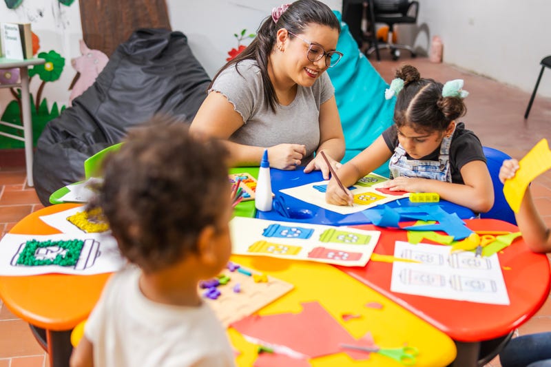 Stock image of preschool teacher with students