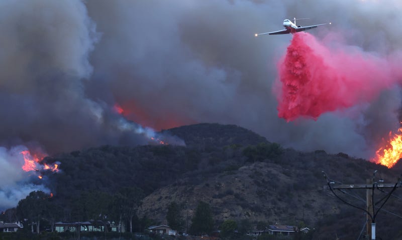 A firefighting aircraft drops the fire retardant Phos-Chek as the Palisades Fire burns amid a powerful windstorm on January 7, 2025 in Pacific Palisades, California.