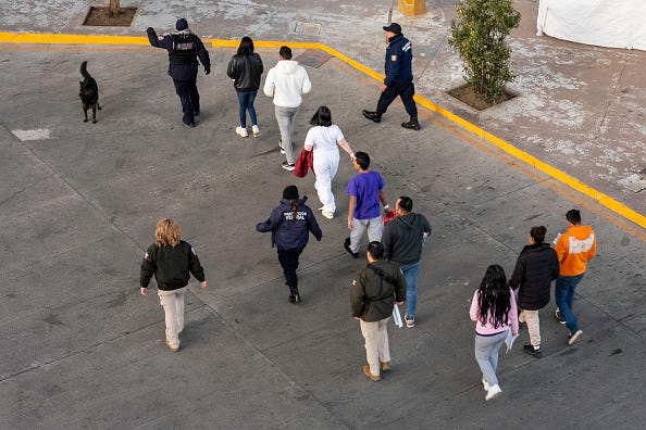 In this aerial view, Mexican immigration officials and police escort deportees after they were sent back into Mexico on January 22, 2025 as seen from Nogales, Arizona. U.S. President Donald Trump signed executive orders on his first day in office declaring a state of emergency at the U.S. southern border, halting asylum claims and launching a campaign of mass deportations. (Photo by John Moore/Getty Images)