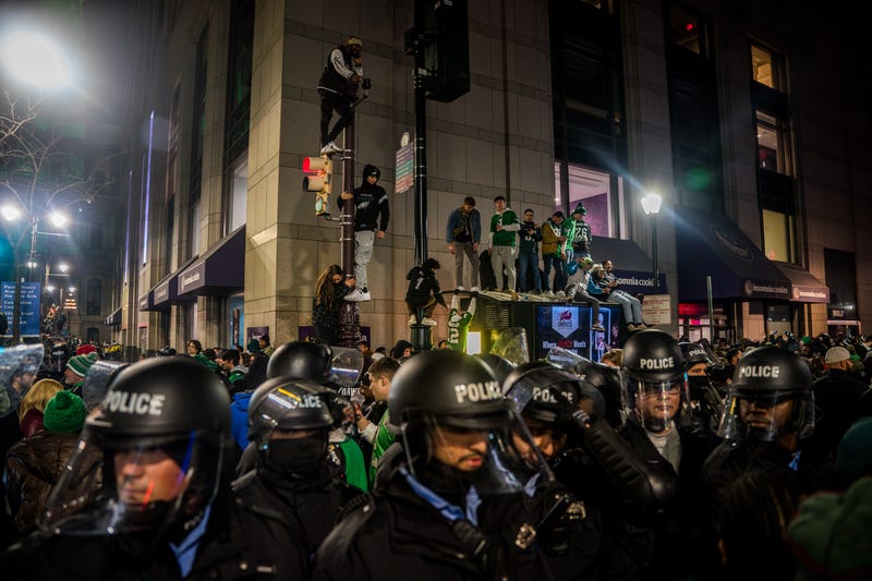 People climb poles following the Philadelphia Eagles' NFC championship win in Philadelphia, Jan. 26, 2025. 