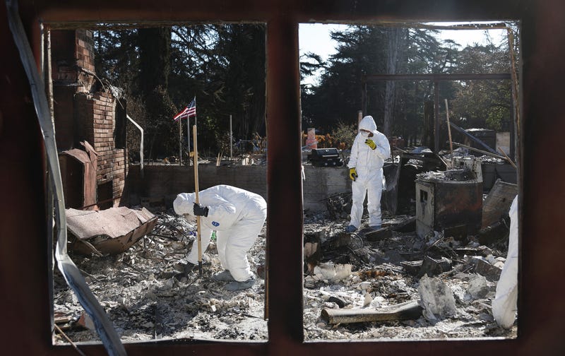 people searching through burned apartment