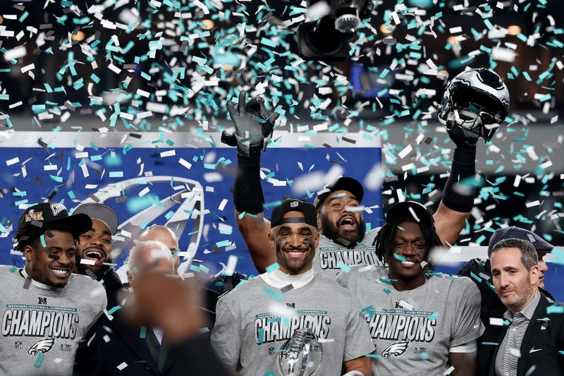 Jalen Hurts #1 of the Philadelphia Eagles and teammates celebrate during the trophy ceremony after their 55-23 win against the Washington Commanders during the NFC Championship Game at Lincoln Financial Field.