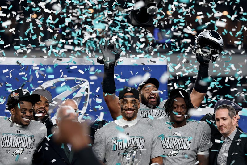 Jalen Hurts and his Philadelphia Eagles teammates celebrate during the trophy ceremony after their 55-23 win against the Washington Commanders during the NFC championship game at Lincoln Financial Field on Sunday. 