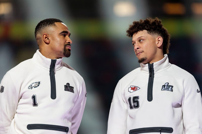 Jalen Hurts of the Philadelphia Eagles and Patrick Mahomes of the Kansas City Chiefs chat on stage during Super Bowl LIX Opening Night on Feb. 3, 2025.