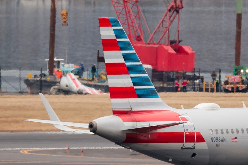 ARLINGTON, VIRGINIA - FEBRUARY 05: An American Airlines flight prepares to take off as pieces of American Airlines flight 5342 recovered from the Potomac River are brought to shore during recovery efforts on February 05, 2025 in Arlington, Virginia. An American Airlines flight from Wichita, Kansas collided midair with a military Black Hawk helicopter while on approach to Ronald Reagan Washington National Airport on January 29, 2025 outside of Washington, DC. (Photo by Kayla Bartkowski/Getty Images)